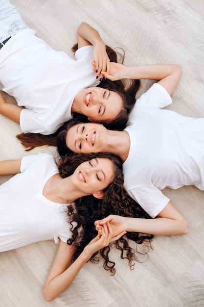 Tres hermosas chicas se unen en el suelo