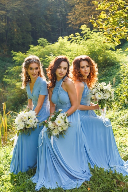 Tres hermosas damas de honor en el parque el día de la boda.