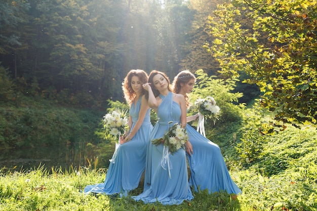 Tres hermosas damas de honor en el parque el día de la boda.