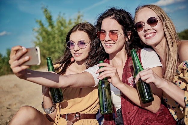 Tres hermosas mujeres jóvenes haciendo un selfie en la playa