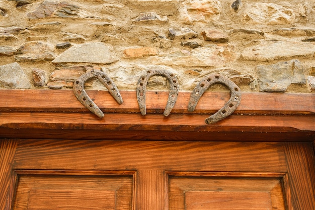 Tres herraduras de hierro para símbolos de buena suerte en una puerta de madera Talismán Superstición