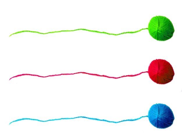 Tres de hilo de tejer sobre fondo blanco.