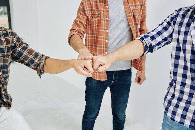 Foto três homens batendo os punhos