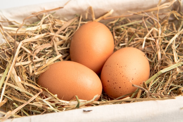 Tres huevos en una canasta blanca