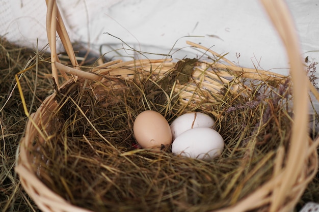 Tres huevos en una canasta de paja. Estilo rústico. Concepto de agricultura y pascua