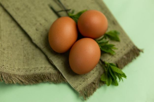 Tres huevos en un paño verde con hojas