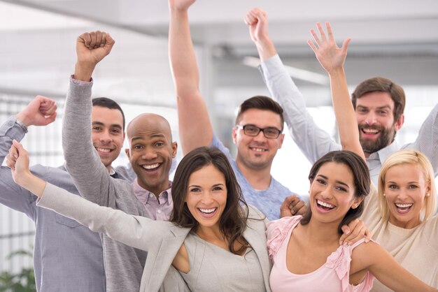 Tres hurras por el éxito empresarial. Captura recortada de un grupo de empresarios sonriendo y levantando la mano.