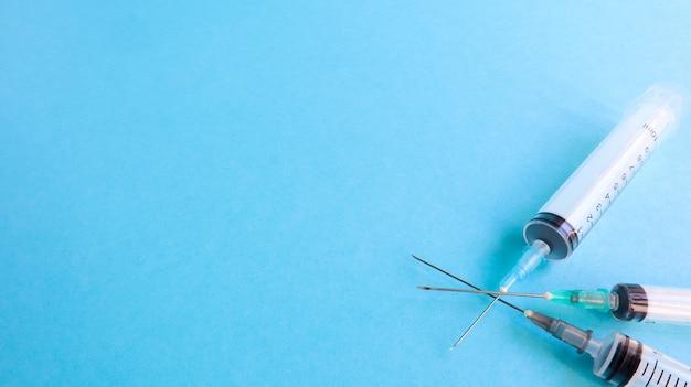 Foto tres jeringas vacías de plástico desechables médicas con agujas de diferentes tamaños y volúmenes. concepto de vacunación, cuarentena, autoaislamiento, protección contra coronavirus, medicina. copie el espacio.