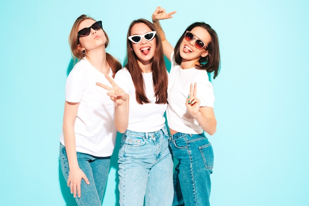 Foto tres joven hermosa mujer hipster sonriente en ropa de jeans y camiseta blanca de moda del mismo verano