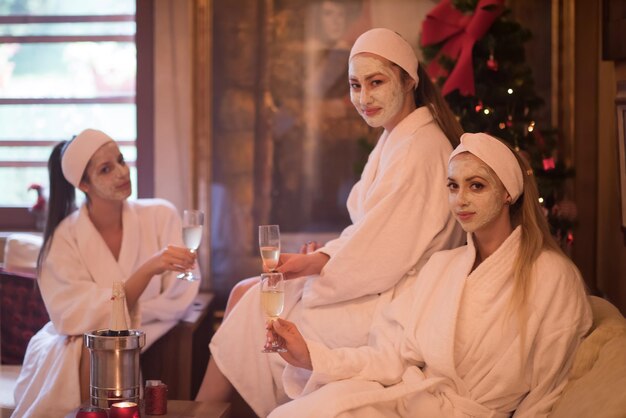 tres jóvenes hermosas chicas felices tienen una despedida de soltero en un spa de lujo con champán