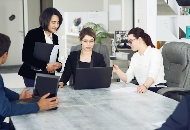 Tres jóvenes mujeres de negocios exitosas en la oficina juntos trabajando felizmente en un proyecto