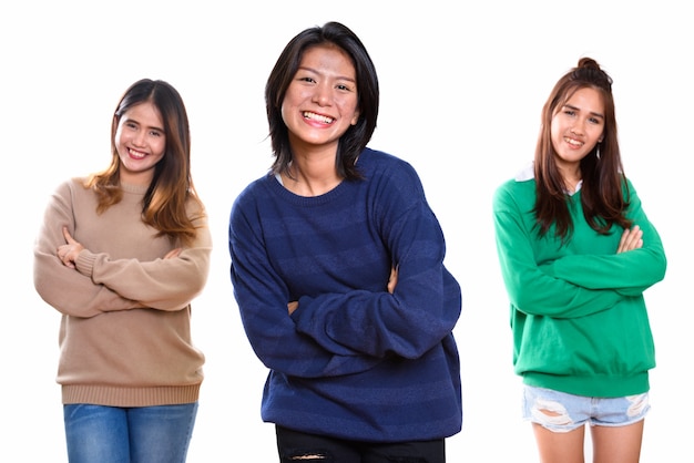 três jovens amigas asiáticas felizes sorrindo com os braços cruzados