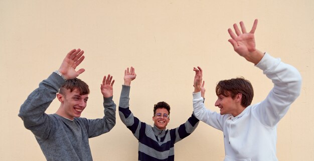 Três jovens amigos alegres dançando e se divertindo em um fundo simples