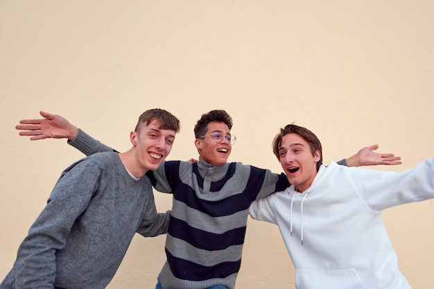 Três jovens amigos alegres se divertindo em um fundo simples