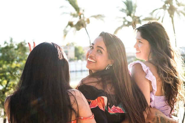 Três jovens amigos ao ar livre curtindo uma bela tarde de verão garotas latinas sentadas juntas