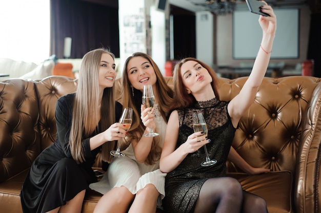 Três jovens estão fazendo foto de selfie em um restaurante.