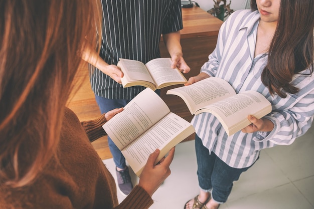 Três jovens formando um círculo e gostando de ler livros juntos