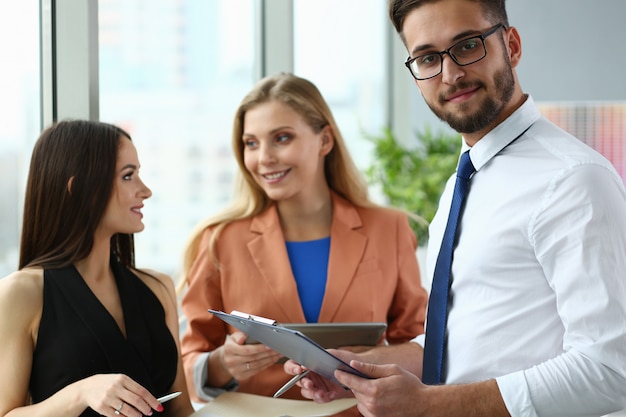 Três jovens funcionários conversando no escritório