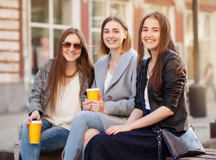 Três jovens mulheres, melhores amigas, sorrindo para a câmera