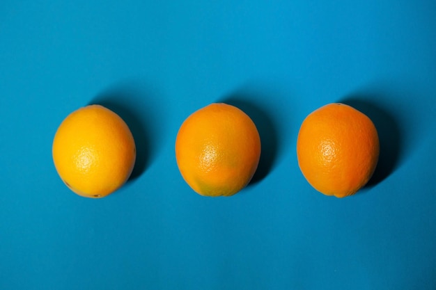 Três laranjas estão em um fundo azul