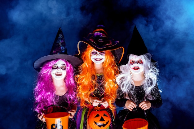 Três linda garota com uma fantasia de bruxa