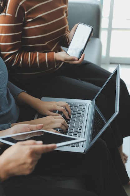 Foto três lindas garotas asiáticas usando smartphone e laptop conversando no sofá juntas no café com espaço de cópia estilo de vida moderno com tecnologia de gadget ou mulher trabalhadora no conceito de negócio casual