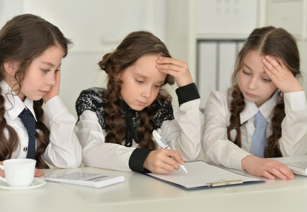 Três lindas garotinhas fazendo lição de casa juntas