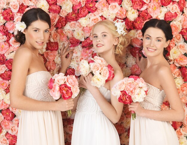 três lindas mulheres com fundo cheio de rosas