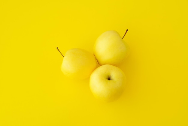 Três maçãs amarelas em um fundo amarelo, frutas maduras amarelas, frutas, maçã, dieta, cor positiva amarela