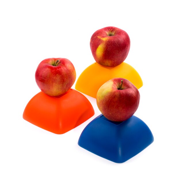 Tres manzanas rojas maduras en una figura amarilla, roja y azul