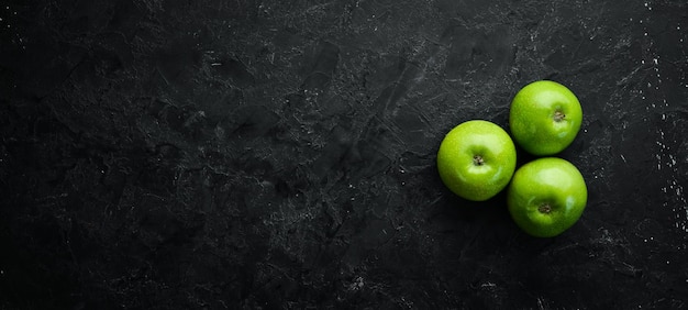 Tres manzanas verdes frescas sobre un fondo de piedra negra Verduras Vista superior Espacio libre para su texto