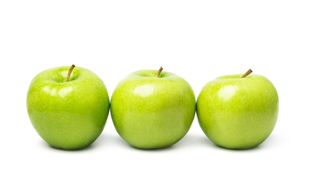 Tres manzanas verdes sobre blanco