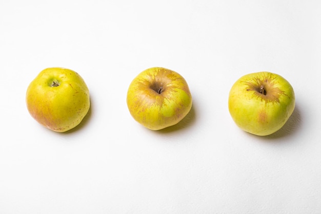 Tres manzanas verdes sobre un fondo blanco.