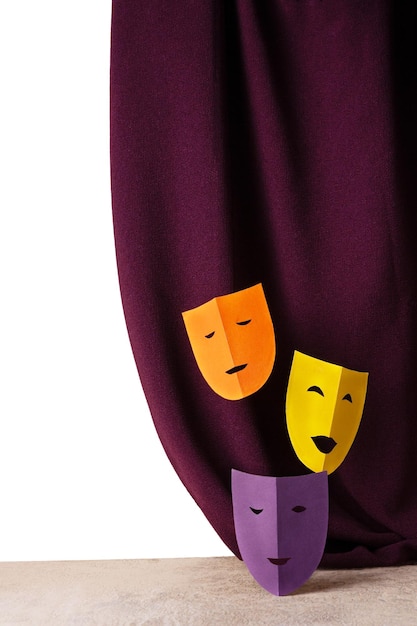 Foto três máscaras teatrais feitas de papel colorido contra o fundo de um espaço de cópia de cortina de veludo