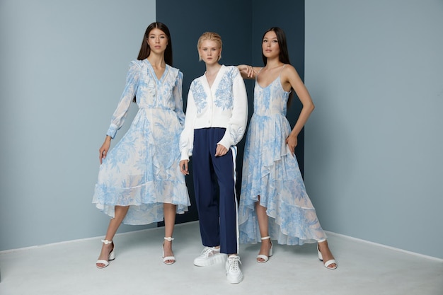 Tres modelos de moda asiáticos con aspecto de vestido azul Rubio con suéter blanco pantalones deportivos pantalones