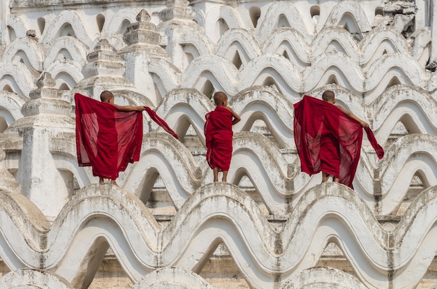 tres monjes jóvenes cambian la túnica en la pagoda de Mya Thein Tan en Bagan, Myanmar