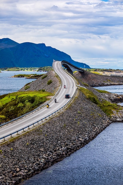 Três motociclistas em motocicletas. Atlantic Ocean Road ou Atlantic Road (Atlanterhavsveien) recebeu o título de "Construção Norueguesa do Século".