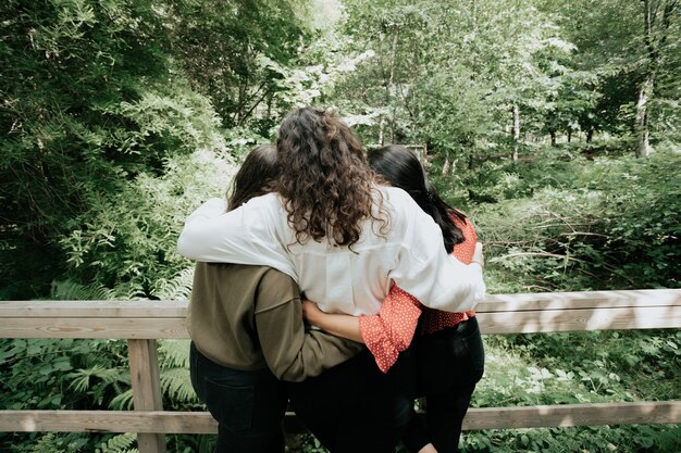 Foto tres mujeres abrazándose, concepto de amor y afecto, concepto de bosque, amistad y cuidado