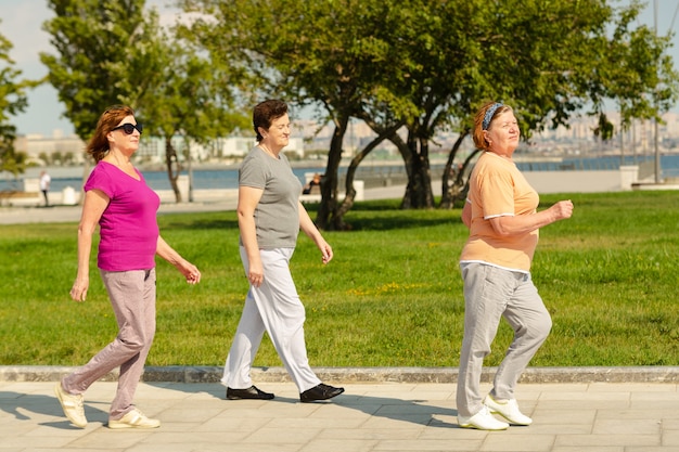 Tres mujeres caminando en un parque público con un estilo de vida saludable para la inmunidad
