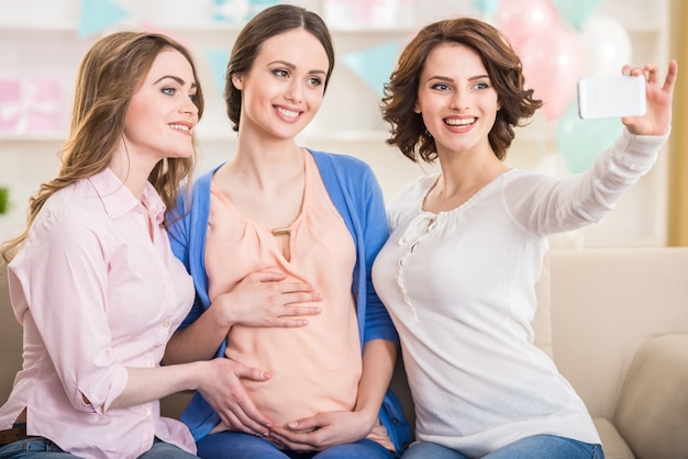 Tres mujeres embarazadas felices están haciendo una foto selfie.