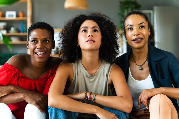 Tres mujeres hispanas y negras de raza mixta que se unen en casa