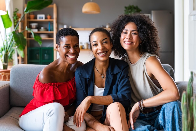 Tres mujeres hispanas y negras de raza mixta que se unen en casa