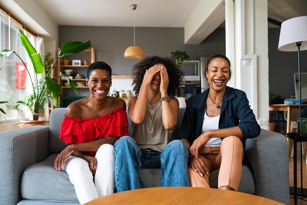 Tres mujeres hispanas y negras de raza mixta que se unen en casa