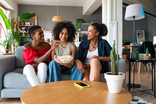 Tres mujeres hispanas y negras de raza mixta que se unen en casa