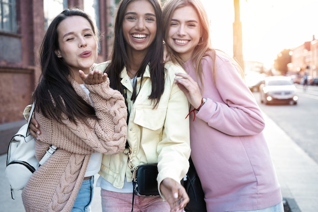 Tres mujeres jóvenes divirtiéndose en las calles de la ciudad