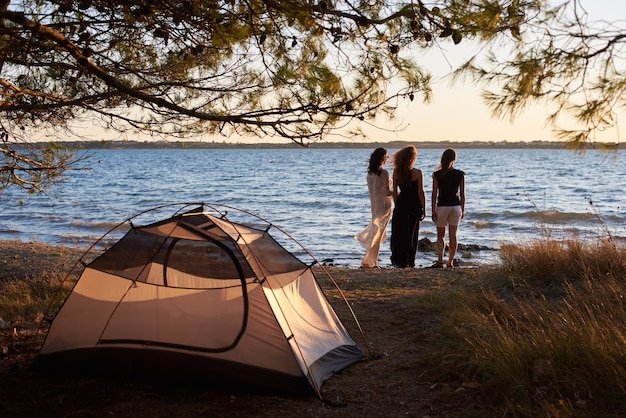 Tres mujeres jóvenes turistas en la orilla del mar