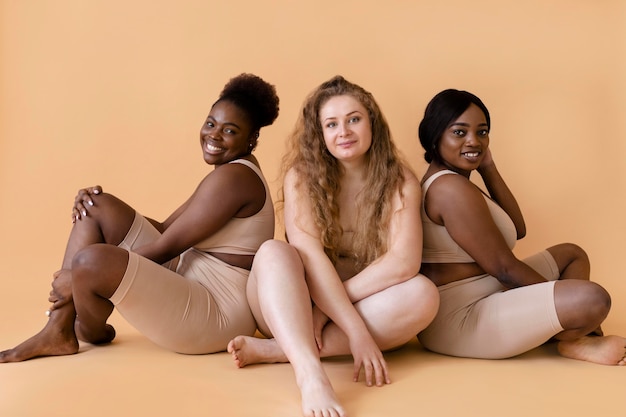 Tres mujeres en modeladores de cuerpo desnudo posando juntos