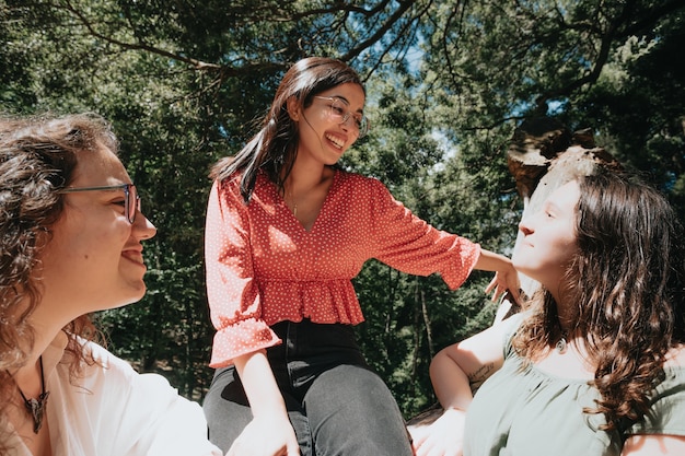 Tres mujeres que tienen un día divertido en el bosque, concepto multicultural y de amistad, cuidado y amor