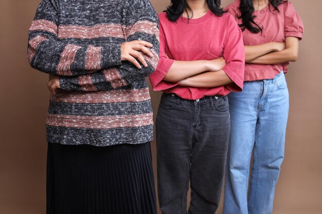 Tres mujeres con ropa casual de pie en una fila con los brazos cruzados Concepto de día de la mujer