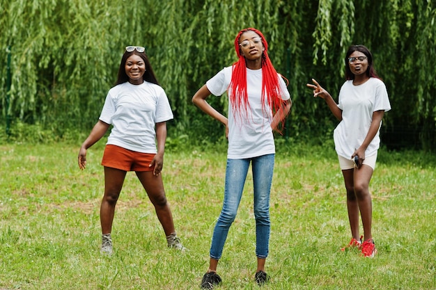 Três mulheres afro-americanas no parque em camisetas brancas